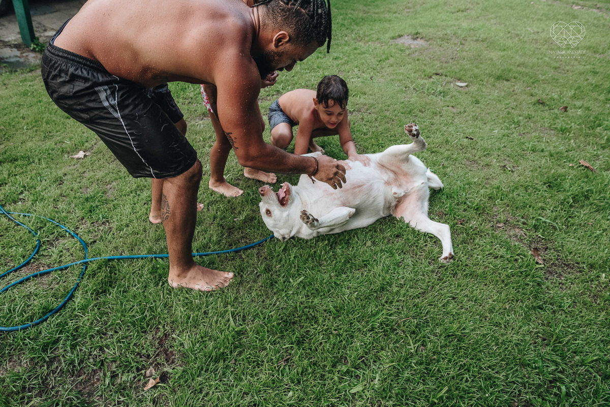 ensaio familia lifestyle brincando de mangueira no quintal de casa com o papai crianças e o cachorro fotografado pela fotografa premiada nayara andrade nayara andrade fotografia