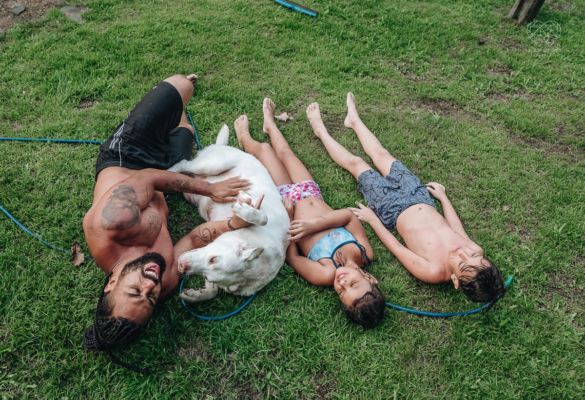 ensaio familia lifestyle brincando de mangueira no quintal de casa com o papai crianças e o cachorro fotografado pela fotografa premiada nayara andrade nayara andrade fotografia