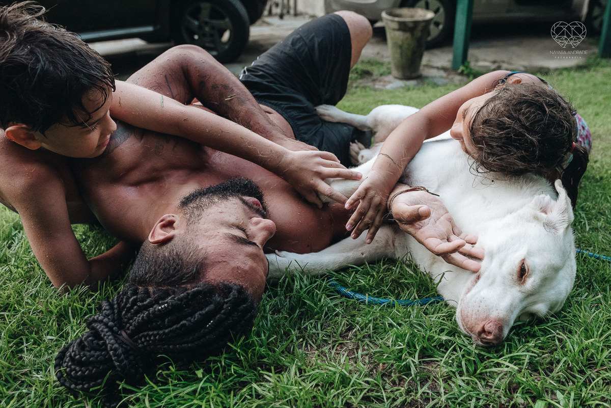 ensaio familia lifestyle brincando de mangueira no quintal de casa com o papai crianças e o cachorro fotografado pela fotografa premiada nayara andrade nayara andrade fotografia