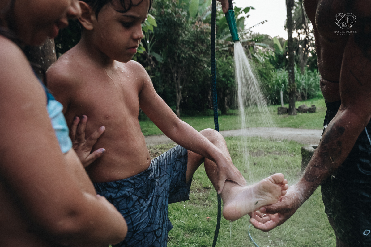 ensaio familia lifestyle brincando de mangueira no quintal de casa com o papai crianças e o cachorro fotografado pela fotografa premiada nayara andrade nayara andrade fotografia