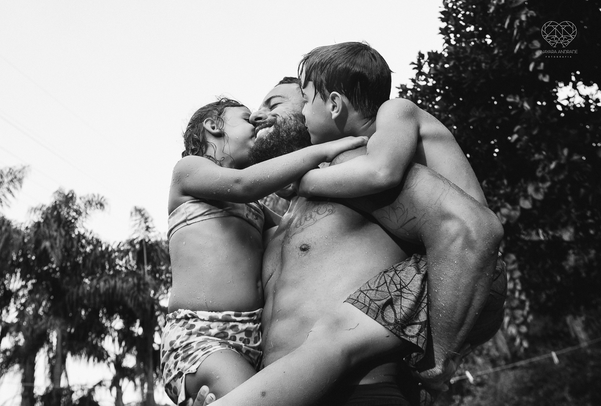 ensaio familia lifestyle brincando de mangueira no quintal de casa com o papai crianças e o cachorro fotografado pela fotografa premiada nayara andrade nayara andrade fotografia