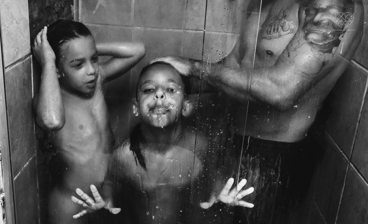 ensaio familia lifestyle brincando de mangueira no quintal de casa com o papai crianças e o cachorro fotografado pela fotografa premiada nayara andrade nayara andrade fotografia