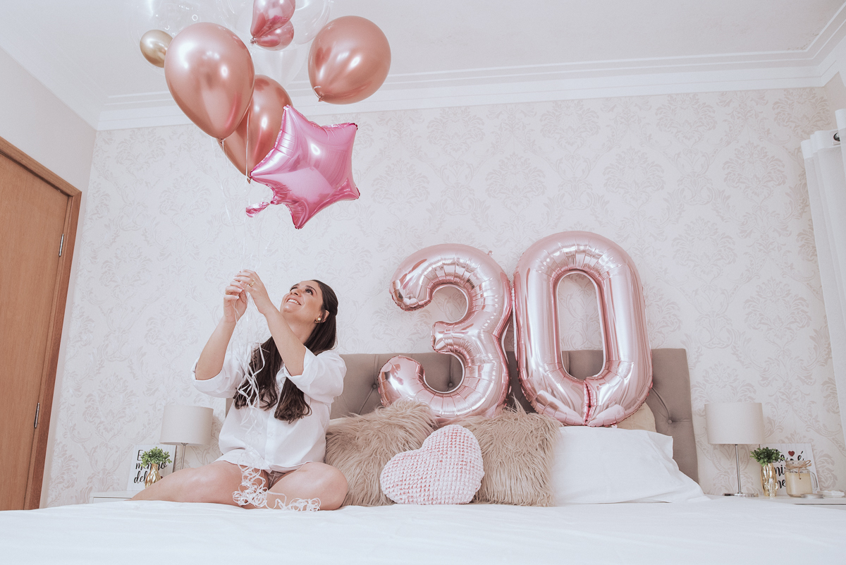 Fotos de mulher comemorando o aniversario no quarto. Ensaio feminino com balão bolo de aniversario tons de rosa e rosado ensaio feito em casa na pandemia pela fotografa premiada nayara andrade em santos guaruja 