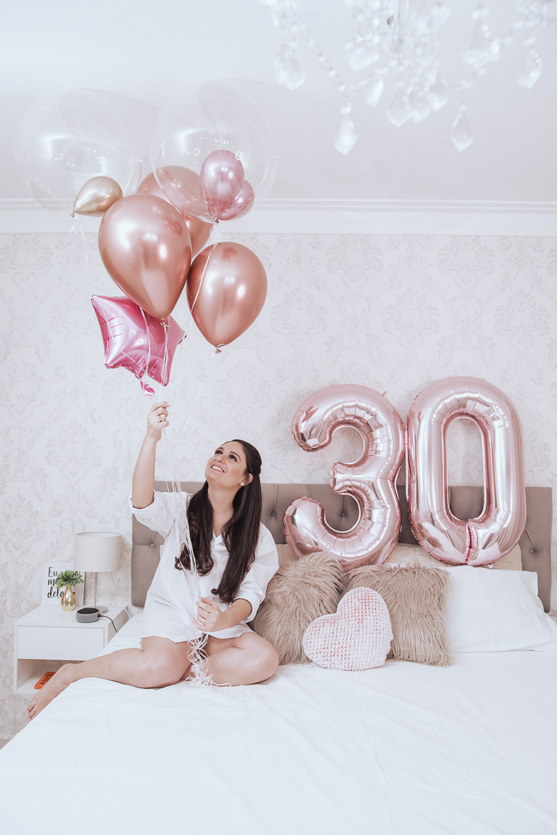 Fotos de mulher comemorando o aniversario no quarto. Ensaio feminino com balão bolo de aniversario tons de rosa e rosado ensaio feito em casa na pandemia pela fotografa premiada nayara andrade em santos guaruja 