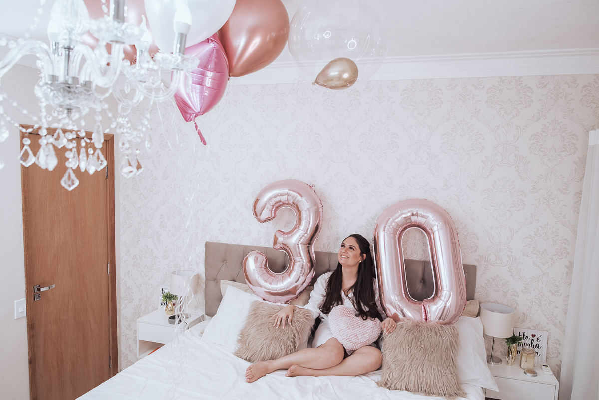 Fotos de mulher comemorando o aniversario no quarto. Ensaio feminino com balão bolo de aniversario tons de rosa e rosado ensaio feito em casa na pandemia pela fotografa premiada nayara andrade em santos guaruja 