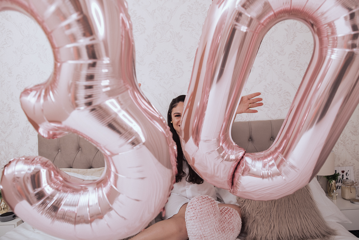Fotos de mulher comemorando o aniversario no quarto. Ensaio feminino com balão bolo de aniversario tons de rosa e rosado ensaio feito em casa na pandemia pela fotografa premiada nayara andrade em santos guaruja 