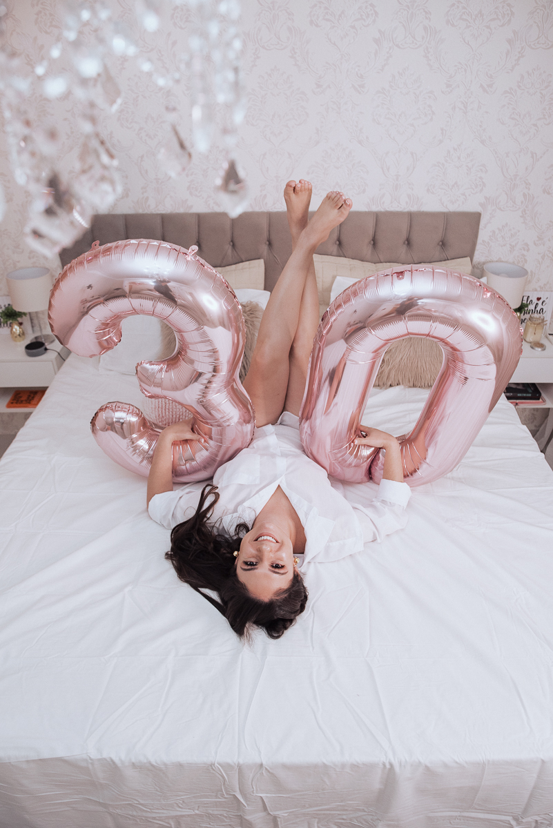 Fotos de mulher comemorando o aniversario no quarto. Ensaio feminino com balão bolo de aniversario tons de rosa e rosado ensaio feito em casa na pandemia pela fotografa premiada nayara andrade em santos guaruja 