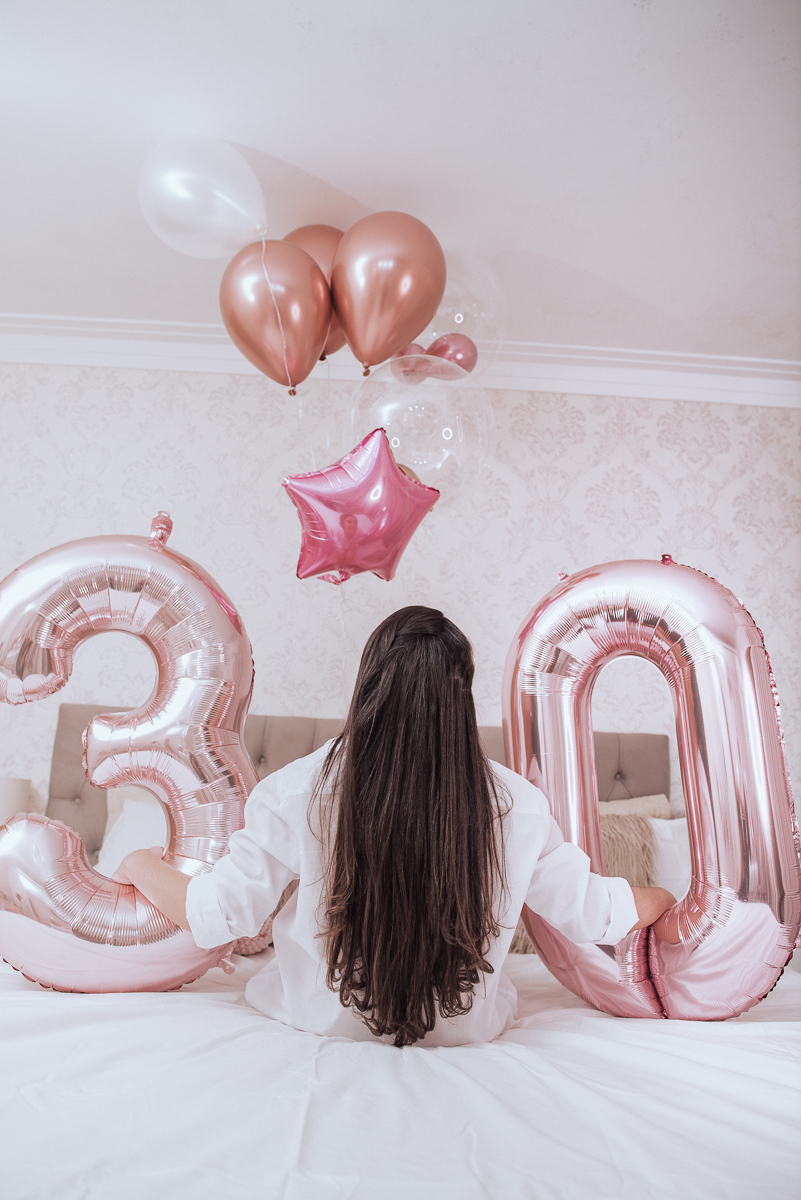 Fotos de mulher comemorando o aniversario no quarto. Ensaio feminino com balão bolo de aniversario tons de rosa e rosado ensaio feito em casa na pandemia pela fotografa premiada nayara andrade em santos guaruja 