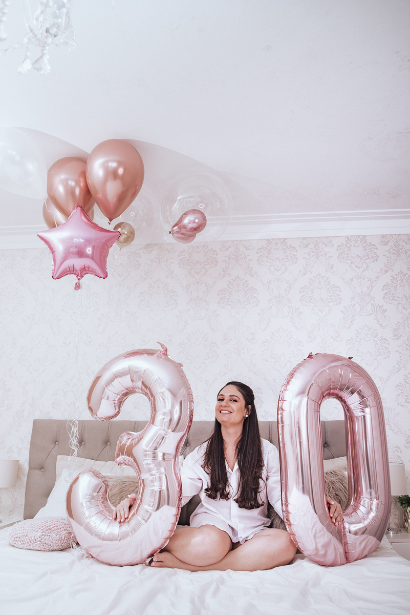 Fotos de mulher comemorando o aniversario no quarto. Ensaio feminino com balão bolo de aniversario tons de rosa e rosado ensaio feito em casa na pandemia pela fotografa premiada nayara andrade em santos guaruja 