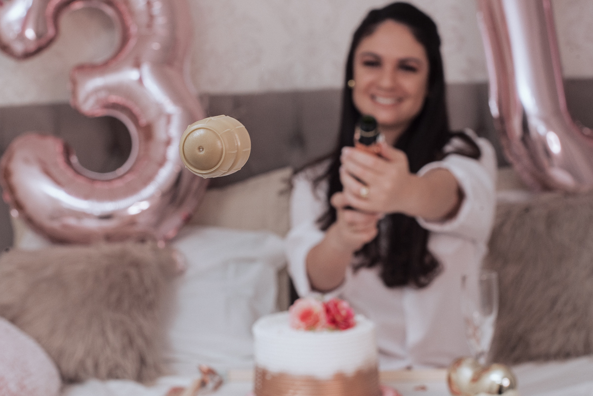 Fotos de mulher comemorando o aniversario no quarto. Ensaio feminino com balão bolo de aniversario tons de rosa e rosado ensaio feito em casa na pandemia pela fotografa premiada nayara andrade em santos guaruja 