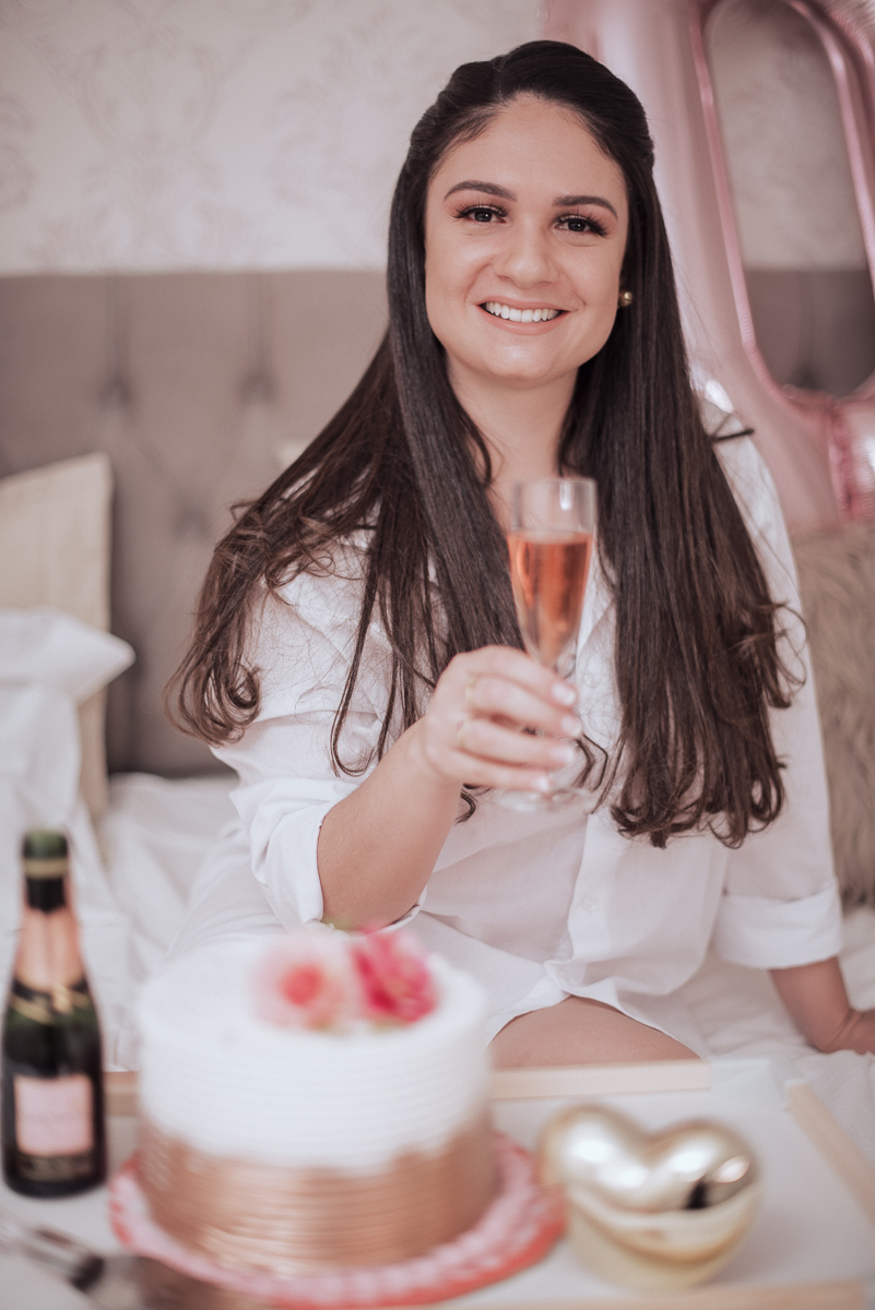Fotos de mulher comemorando o aniversario no quarto. Ensaio feminino com balão bolo de aniversario tons de rosa e rosado ensaio feito em casa na pandemia pela fotografa premiada nayara andrade em santos guaruja 