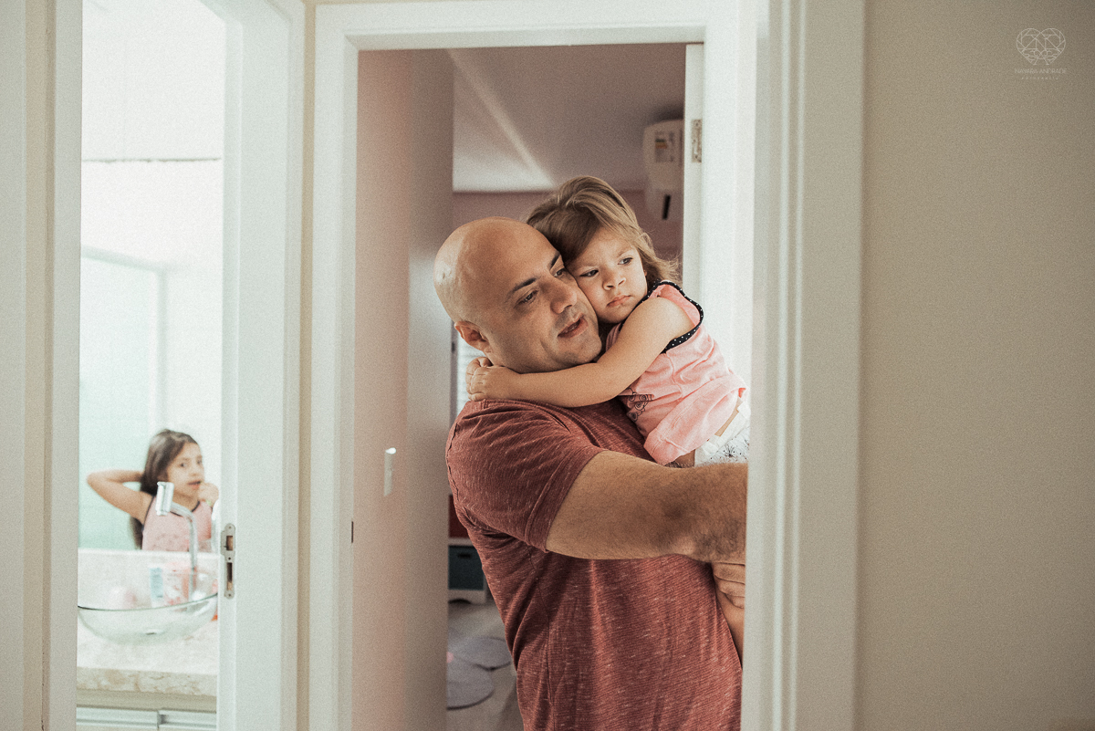 Fotografia de familia fotos feitas em casa ao natural da familia mae pai e duas filhas com pijama acordando brincando no predio. fotos feitas pela fotografa premiada nayara andrade de santos litoral de sao paulo