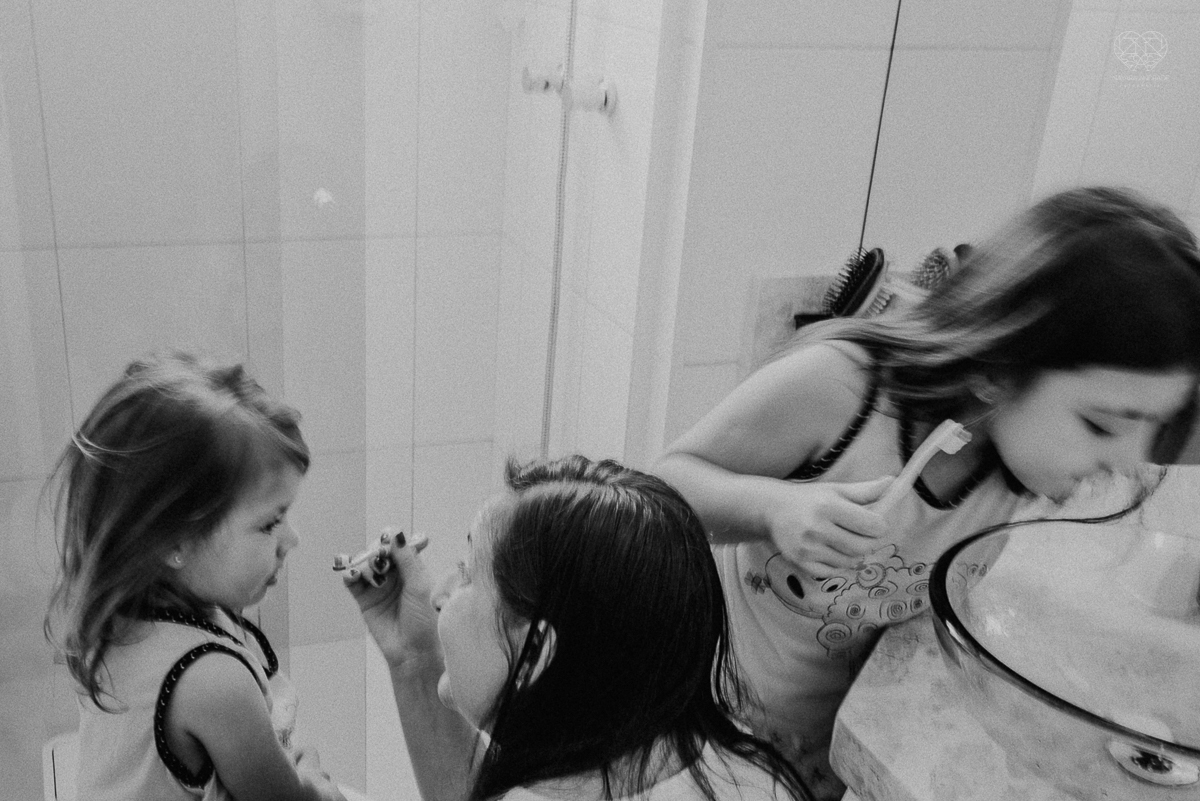 Fotografia de familia fotos feitas em casa ao natural da familia mae pai e duas filhas com pijama acordando brincando no predio. fotos feitas pela fotografa premiada nayara andrade de santos litoral de sao paulo
