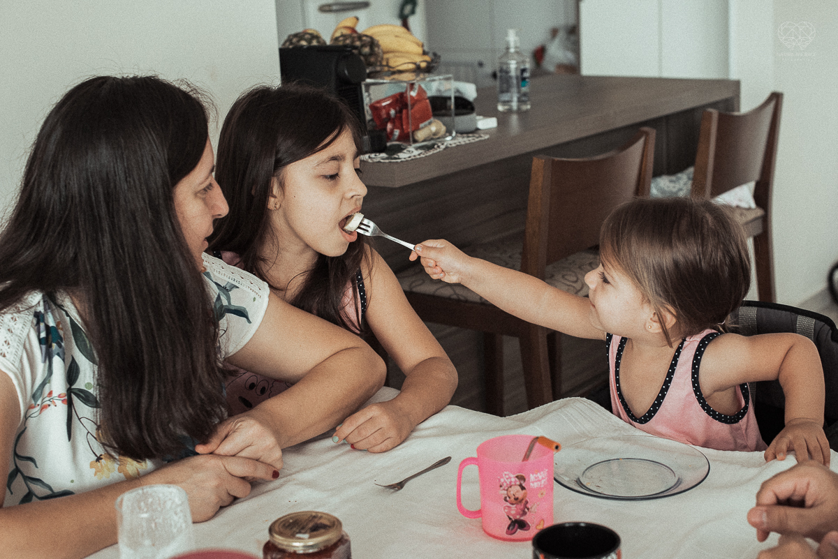 Fotografia de familia fotos feitas em casa ao natural da familia mae pai e duas filhas com pijama acordando brincando no predio. fotos feitas pela fotografa premiada nayara andrade de santos litoral de sao paulo