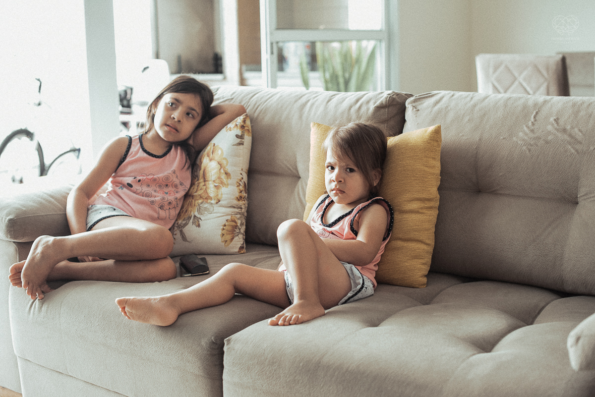 Fotografia de familia fotos feitas em casa ao natural da familia mae pai e duas filhas com pijama acordando brincando no predio. fotos feitas pela fotografa premiada nayara andrade de santos litoral de sao paulo