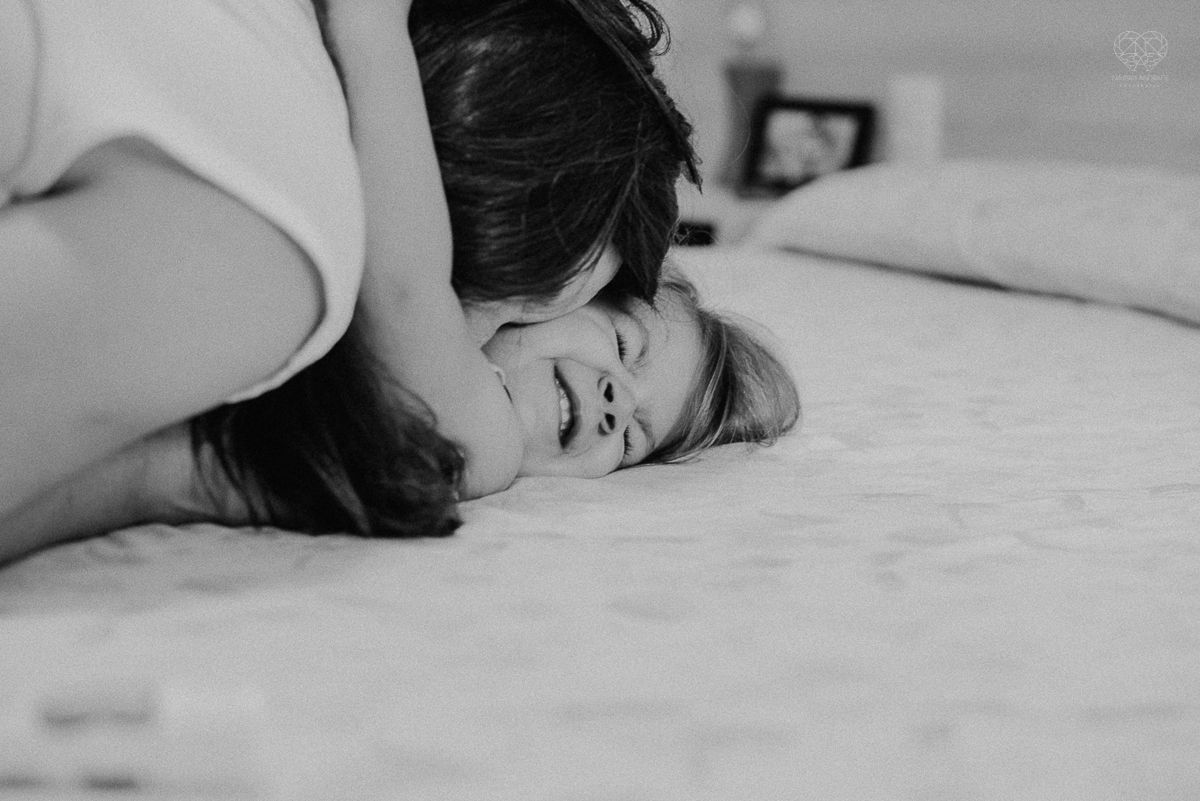 Fotografia de familia fotos feitas em casa ao natural da familia mae pai e duas filhas com pijama acordando brincando no predio. fotos feitas pela fotografa premiada nayara andrade de santos litoral de sao paulo