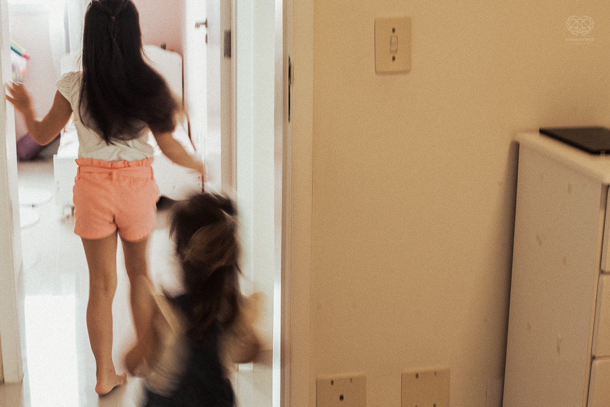 Fotografia de familia fotos feitas em casa ao natural da familia mae pai e duas filhas com pijama acordando brincando no predio. fotos feitas pela fotografa premiada nayara andrade de santos litoral de sao paulo