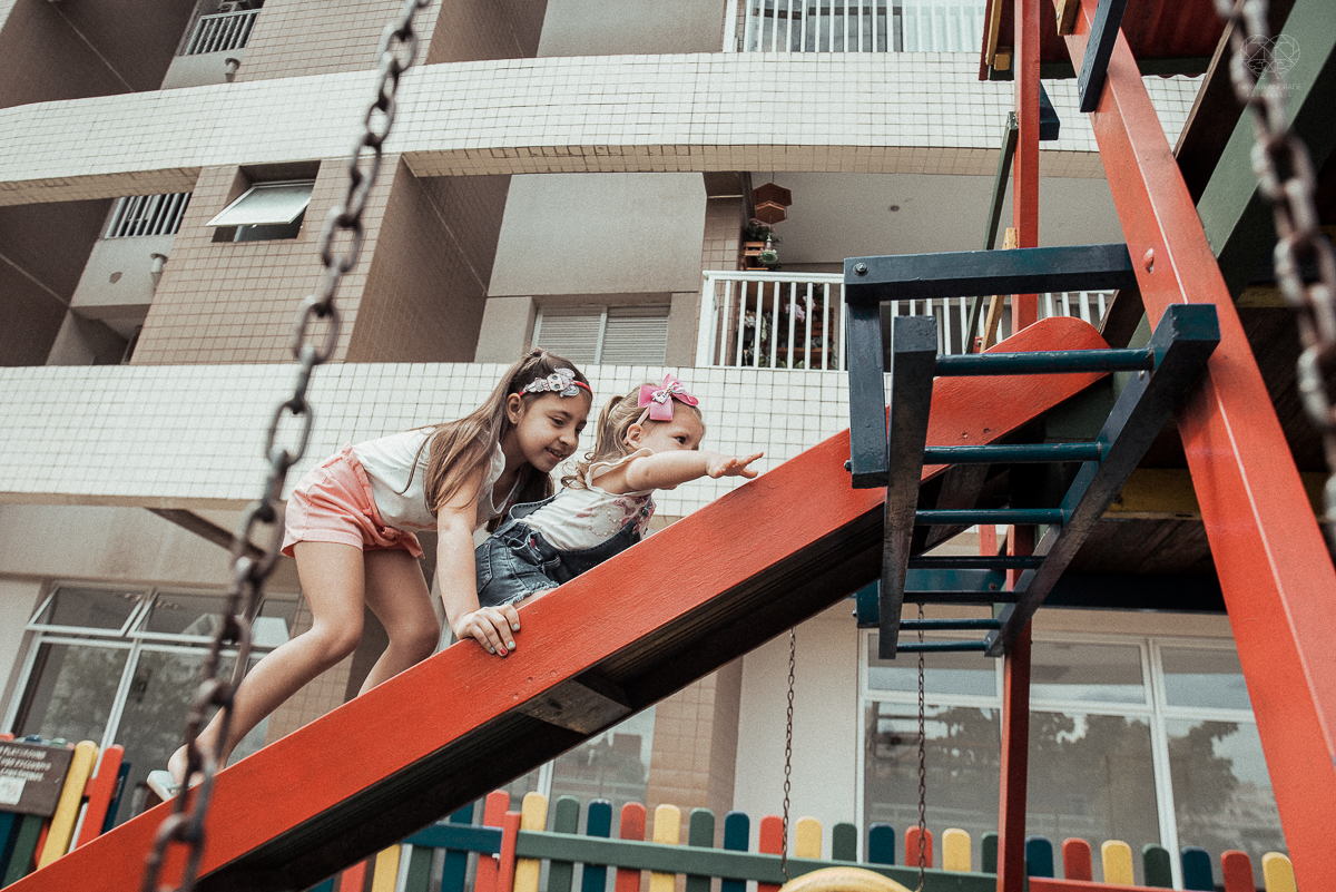 Fotografia de familia fotos feitas em casa ao natural da familia mae pai e duas filhas com pijama acordando brincando no predio. fotos feitas pela fotografa premiada nayara andrade de santos litoral de sao paulo