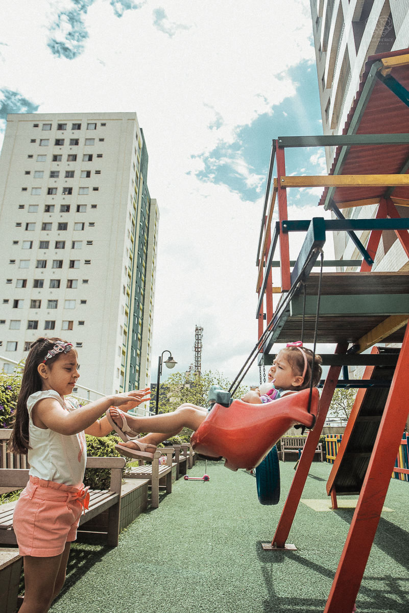 Fotografia de familia fotos feitas em casa ao natural da familia mae pai e duas filhas com pijama acordando brincando no predio. fotos feitas pela fotografa premiada nayara andrade de santos litoral de sao paulo