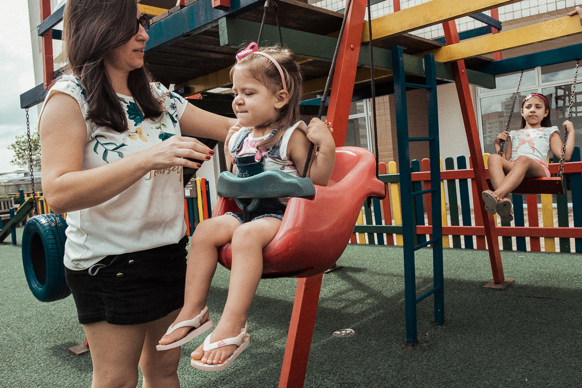 Fotografia de familia fotos feitas em casa ao natural da familia mae pai e duas filhas com pijama acordando brincando no predio. fotos feitas pela fotografa premiada nayara andrade de santos litoral de sao paulo
