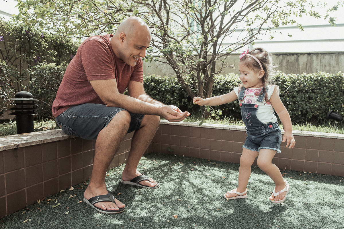 Fotografia de familia fotos feitas em casa ao natural da familia mae pai e duas filhas com pijama acordando brincando no predio. fotos feitas pela fotografa premiada nayara andrade de santos litoral de sao paulo