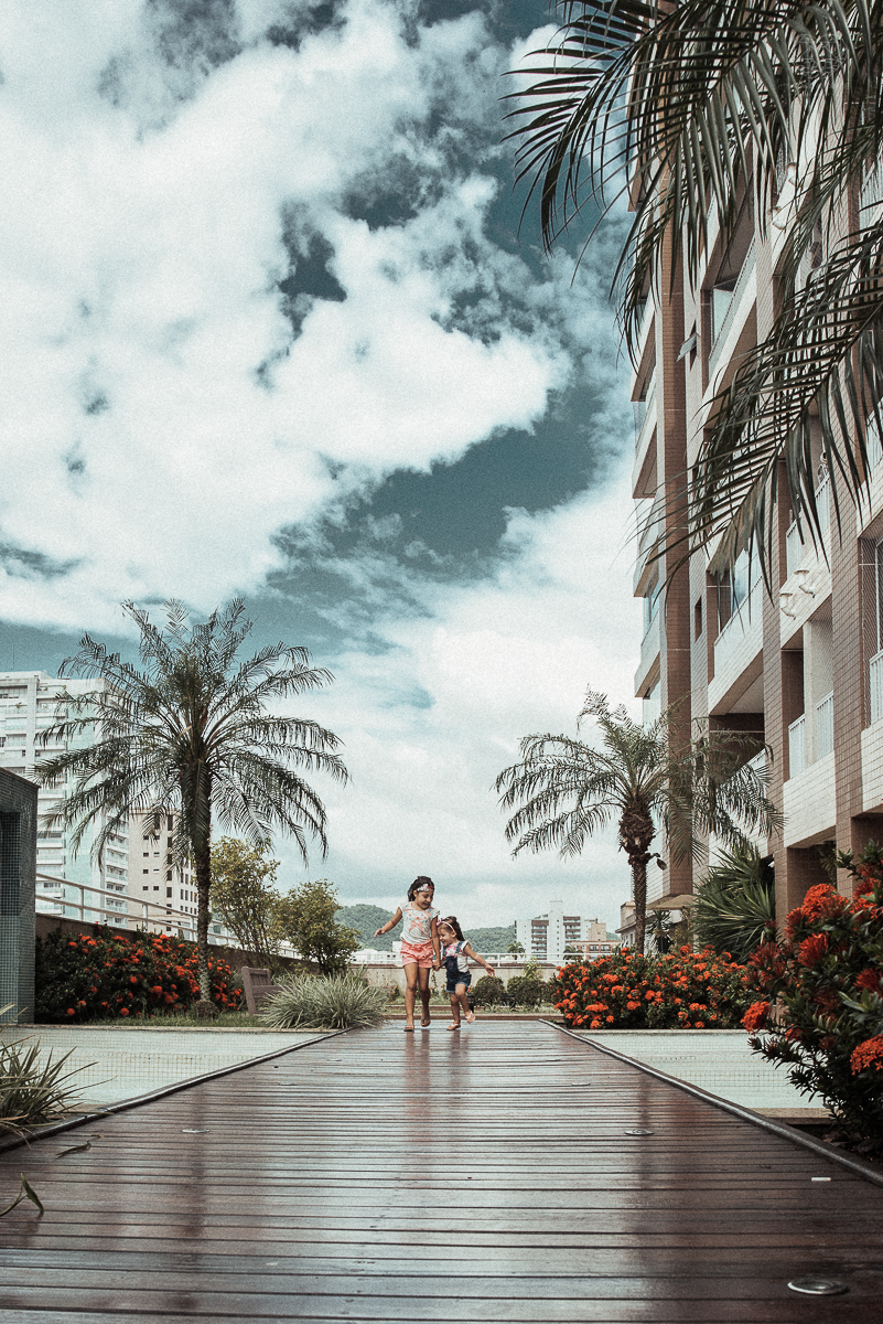 Fotografia de familia fotos feitas em casa ao natural da familia mae pai e duas filhas com pijama acordando brincando no predio. fotos feitas pela fotografa premiada nayara andrade de santos litoral de sao paulo