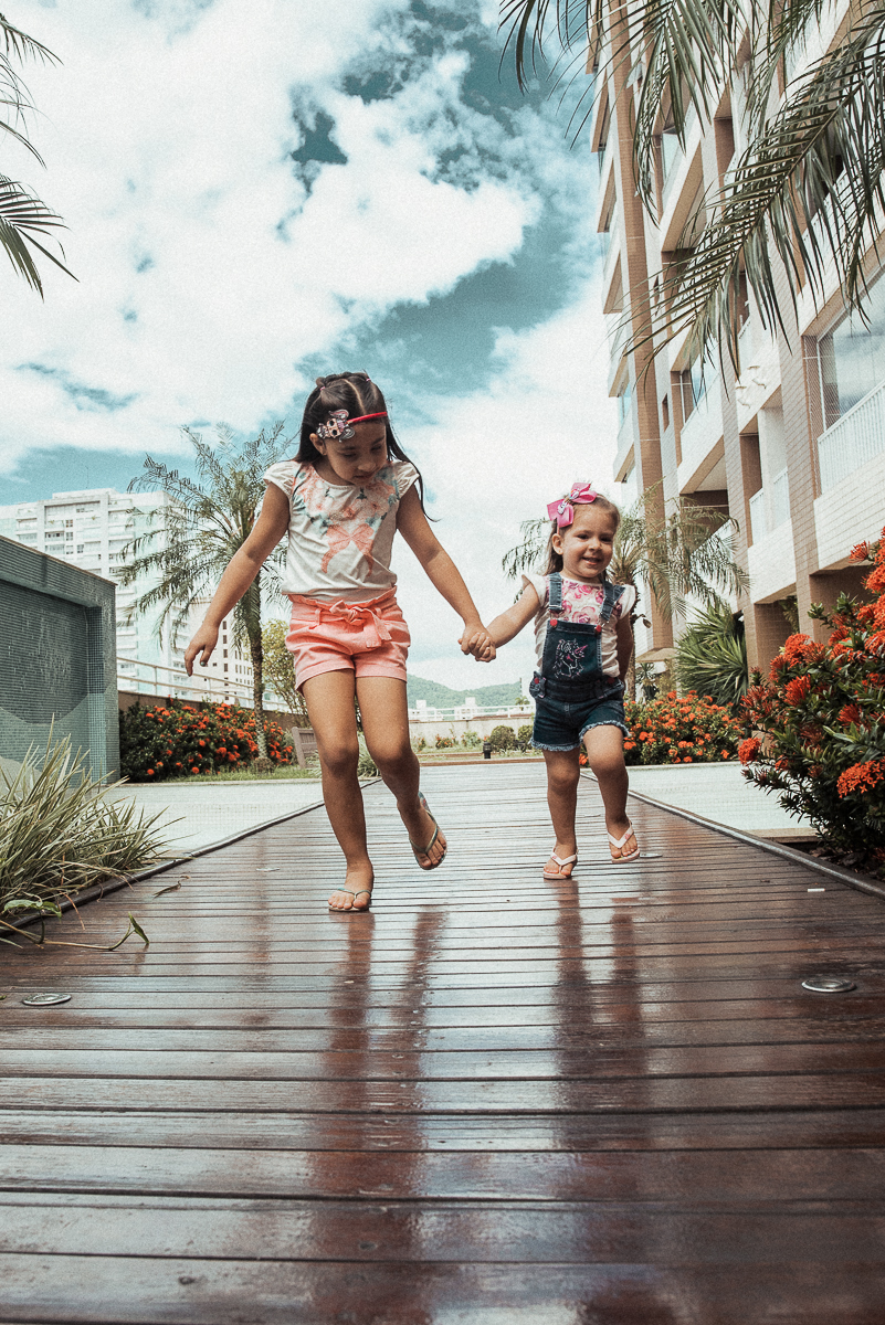 Fotografia de familia fotos feitas em casa ao natural da familia mae pai e duas filhas com pijama acordando brincando no predio. fotos feitas pela fotografa premiada nayara andrade de santos litoral de sao paulo