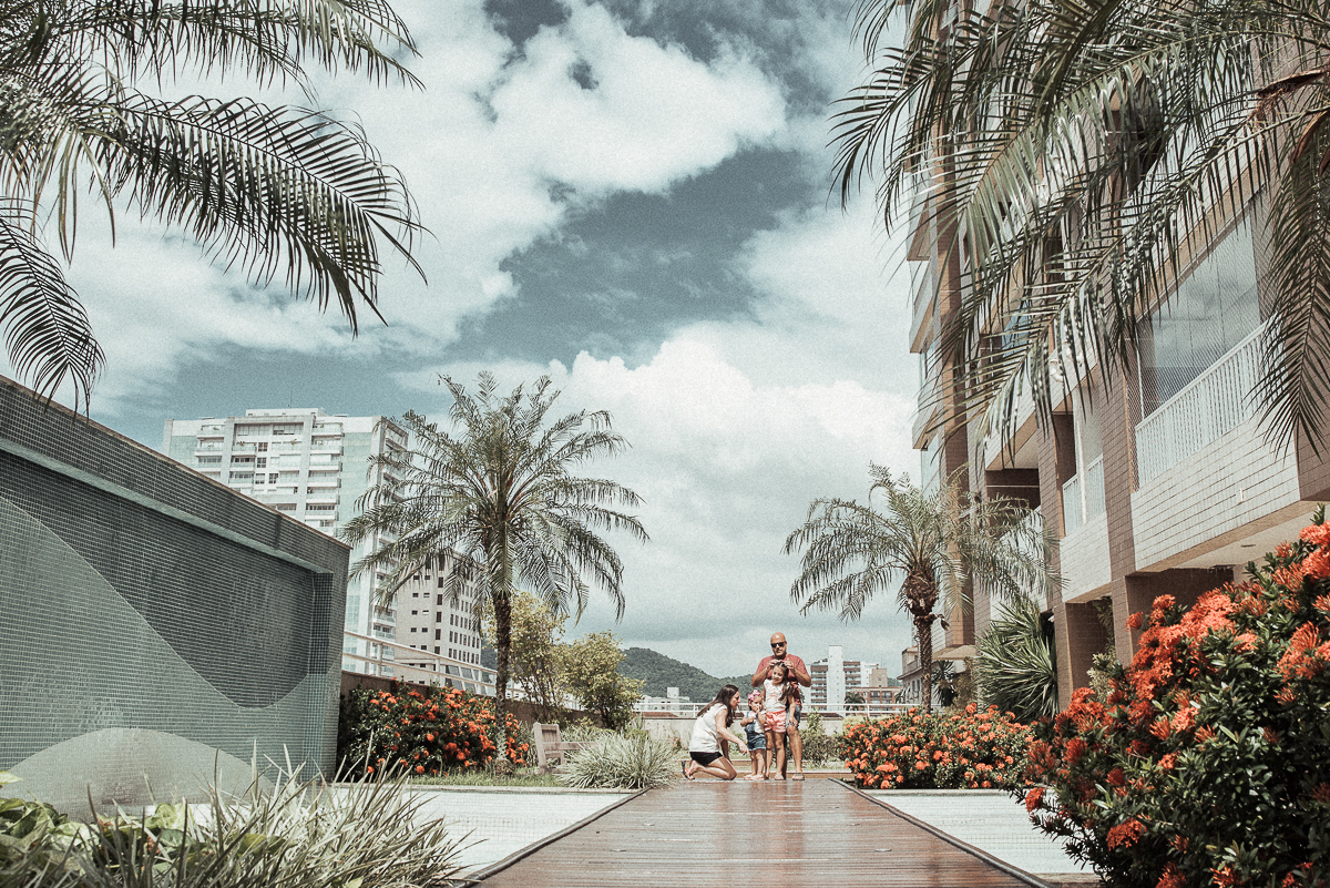Fotografia de familia fotos feitas em casa ao natural da familia mae pai e duas filhas com pijama acordando brincando no predio. fotos feitas pela fotografa premiada nayara andrade de santos litoral de sao paulo