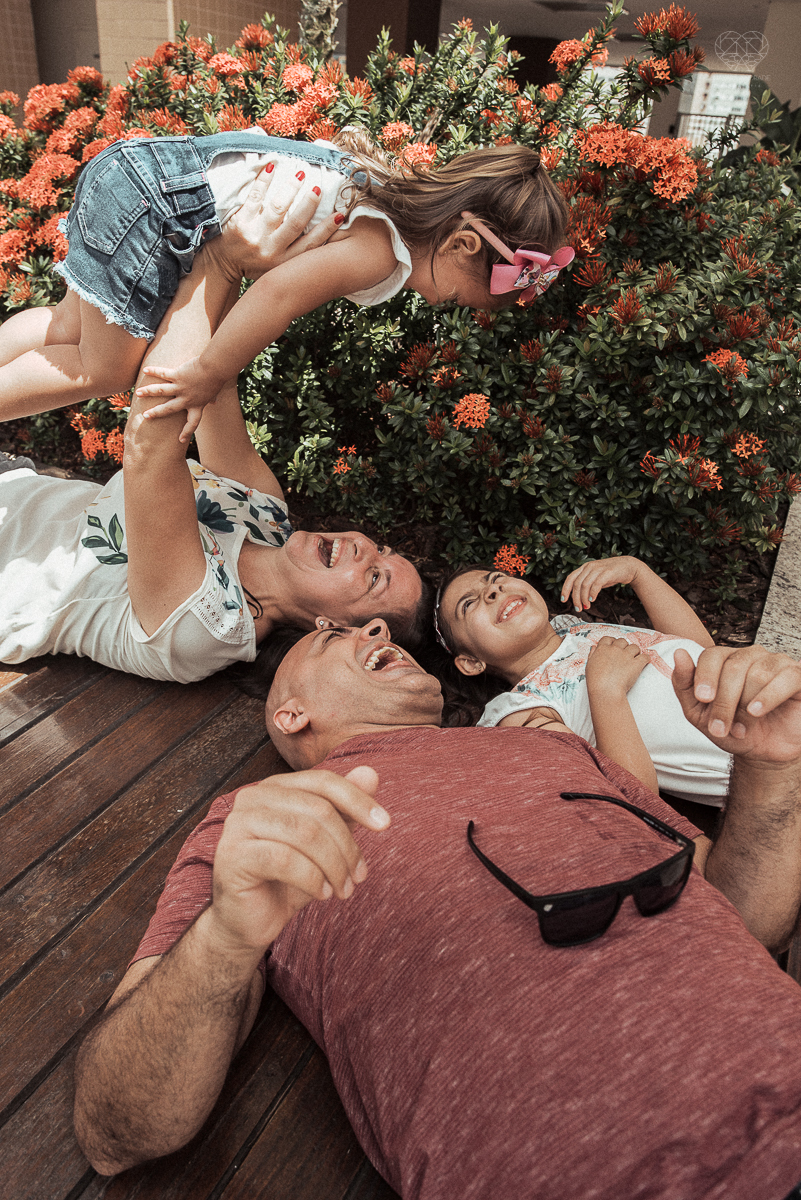 Fotografia de familia fotos feitas em casa ao natural da familia mae pai e duas filhas com pijama acordando brincando no predio. fotos feitas pela fotografa premiada nayara andrade de santos litoral de sao paulo