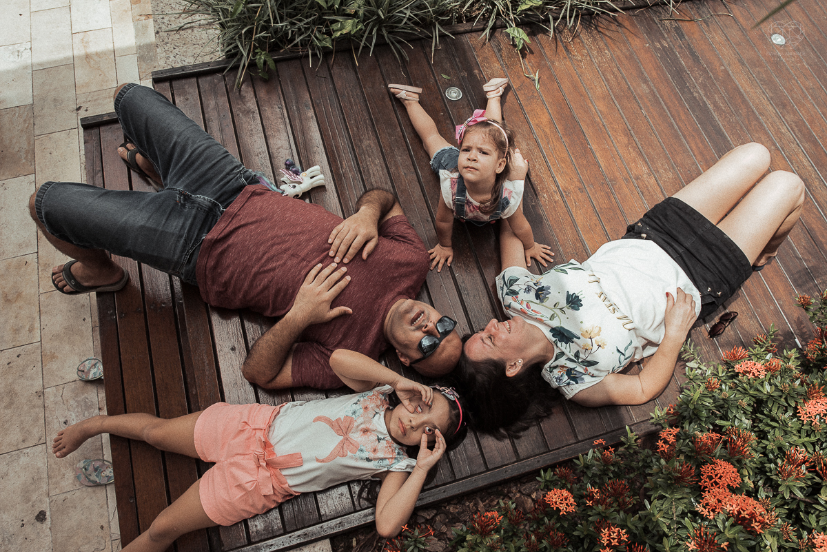 Fotografia de familia fotos feitas em casa ao natural da familia mae pai e duas filhas com pijama acordando brincando no predio. fotos feitas pela fotografa premiada nayara andrade de santos litoral de sao paulo