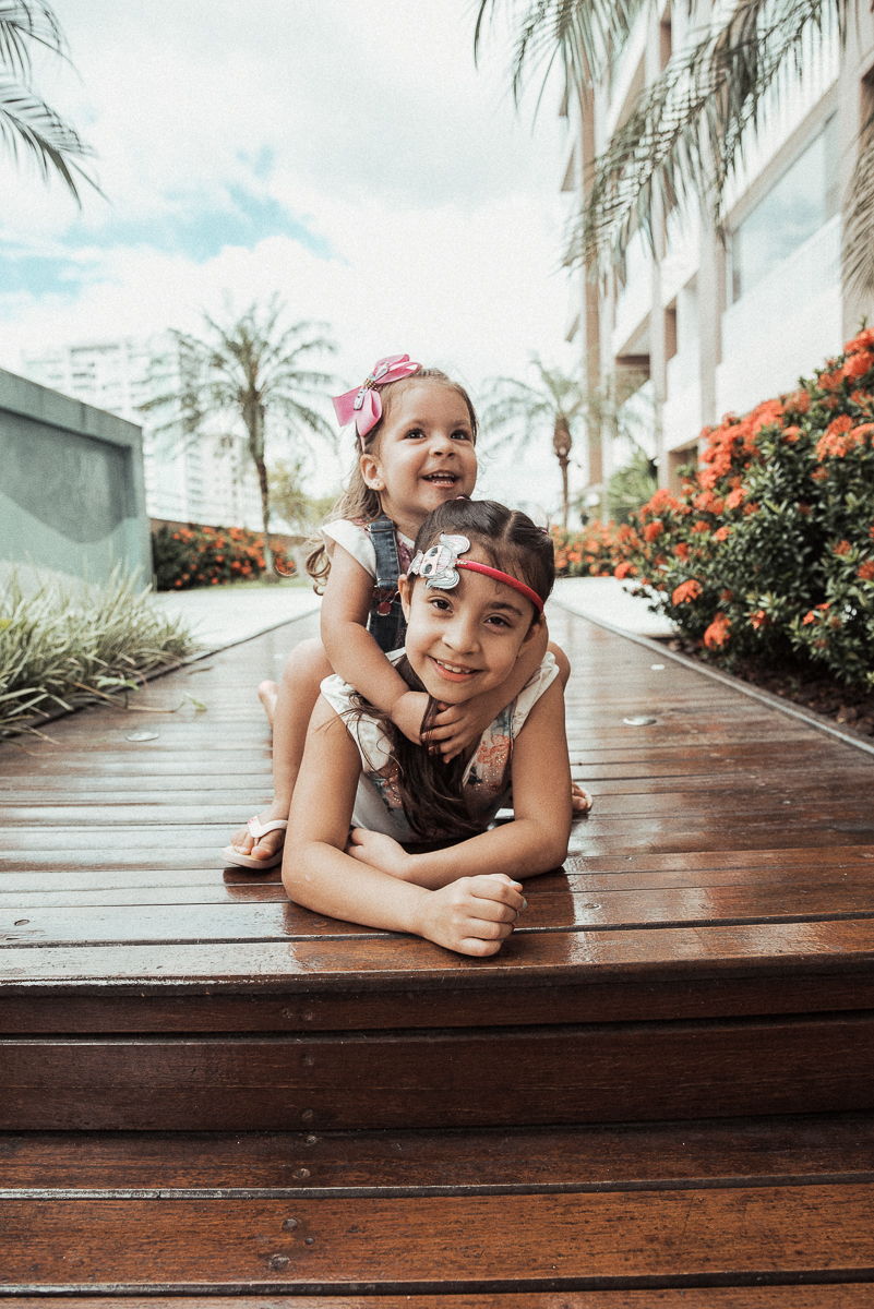 Fotografia de familia fotos feitas em casa ao natural da familia mae pai e duas filhas com pijama acordando brincando no predio. fotos feitas pela fotografa premiada nayara andrade de santos litoral de sao paulo