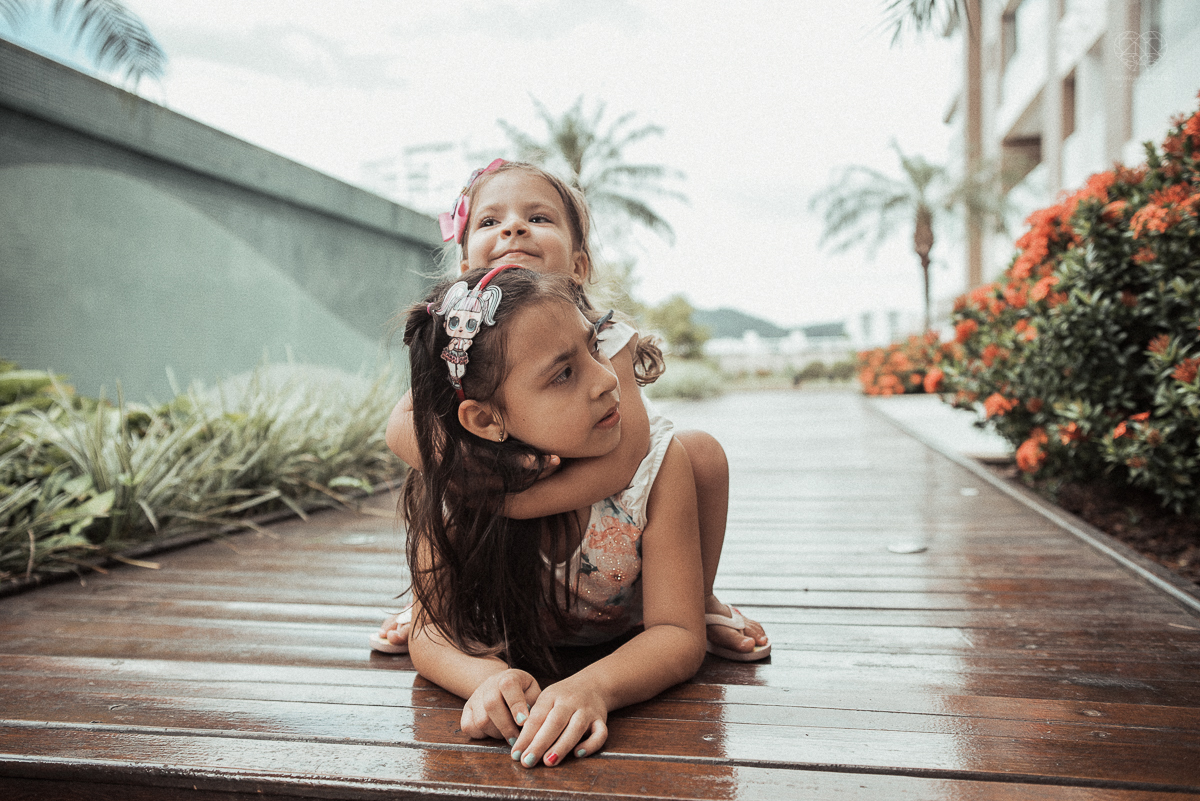 Fotografia de familia fotos feitas em casa ao natural da familia mae pai e duas filhas com pijama acordando brincando no predio. fotos feitas pela fotografa premiada nayara andrade de santos litoral de sao paulo