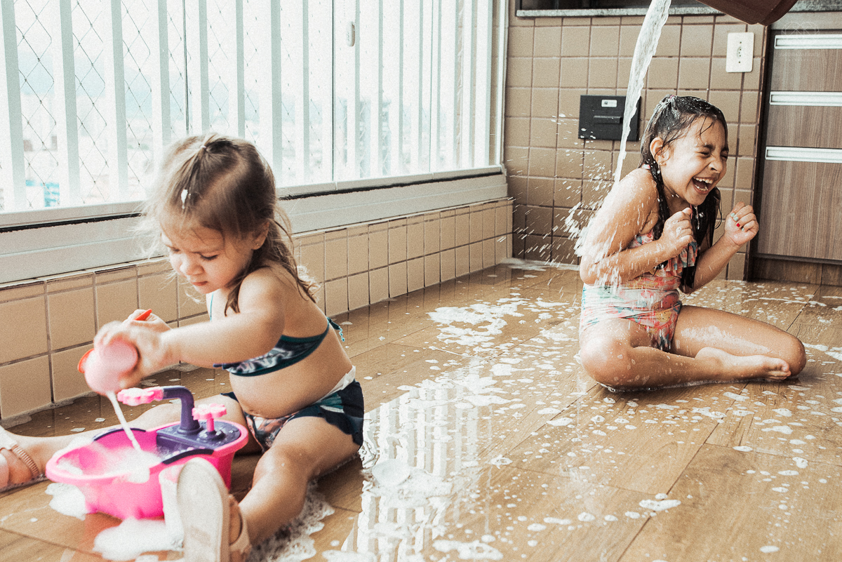 Fotografia de familia fotos feitas em casa ao natural da familia mae pai e duas filhas com pijama acordando brincando no predio. fotos feitas pela fotografa premiada nayara andrade de santos litoral de sao paulo