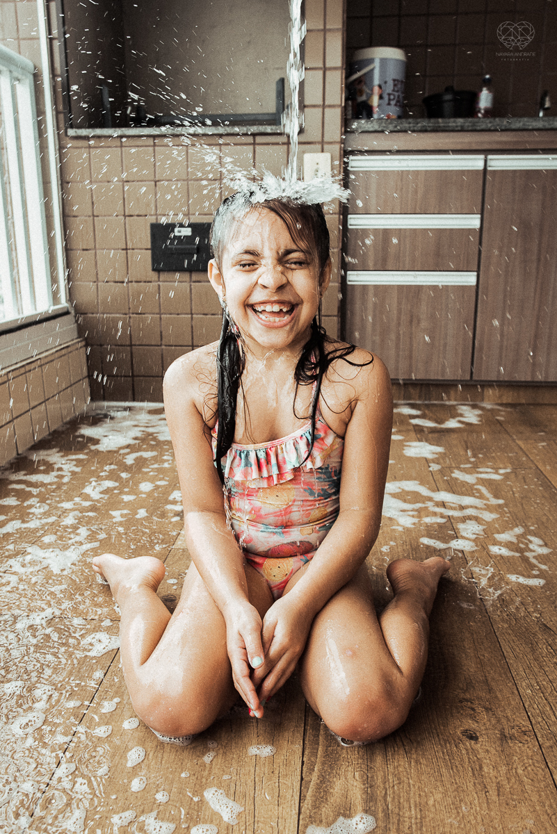 Fotografia de familia fotos feitas em casa ao natural da familia mae pai e duas filhas com pijama acordando brincando no predio. fotos feitas pela fotografa premiada nayara andrade de santos litoral de sao paulo