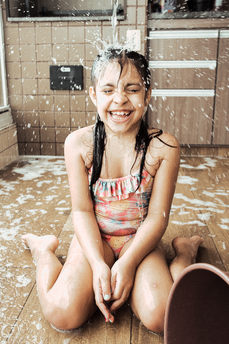 Fotografia de familia fotos feitas em casa ao natural da familia mae pai e duas filhas com pijama acordando brincando no predio. fotos feitas pela fotografa premiada nayara andrade de santos litoral de sao paulo