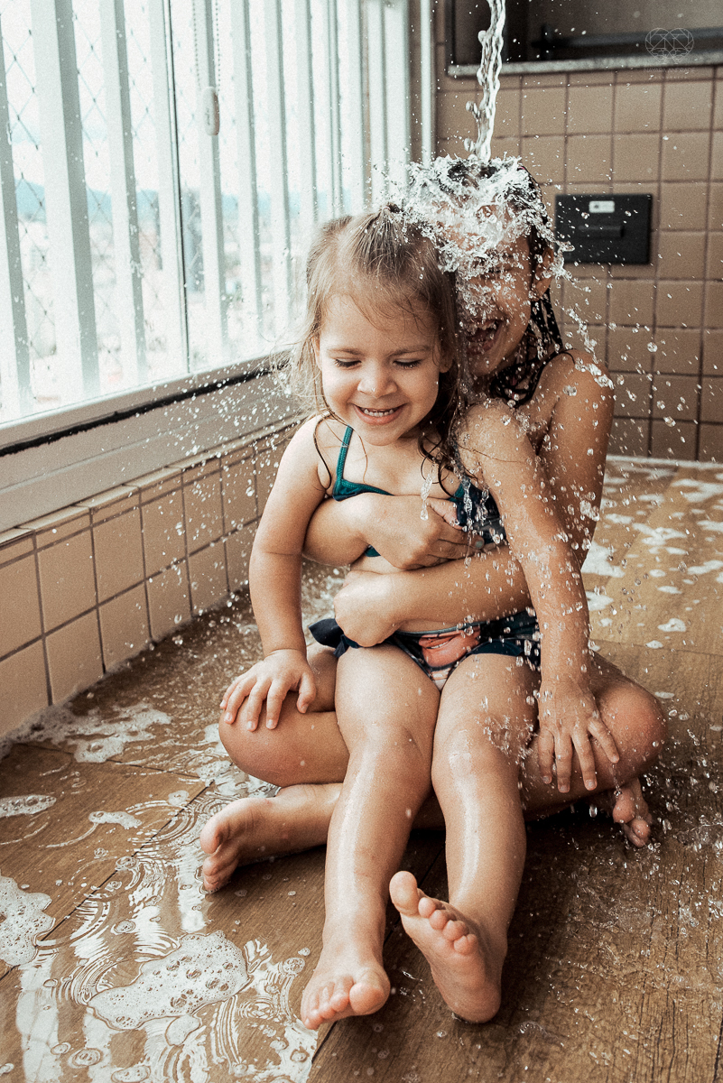 Fotografia de familia fotos feitas em casa ao natural da familia mae pai e duas filhas com pijama acordando brincando no predio. fotos feitas pela fotografa premiada nayara andrade de santos litoral de sao paulo