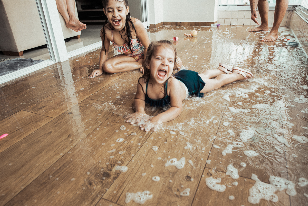 Fotografia de familia fotos feitas em casa ao natural da familia mae pai e duas filhas com pijama acordando brincando no predio. fotos feitas pela fotografa premiada nayara andrade de santos litoral de sao paulo
