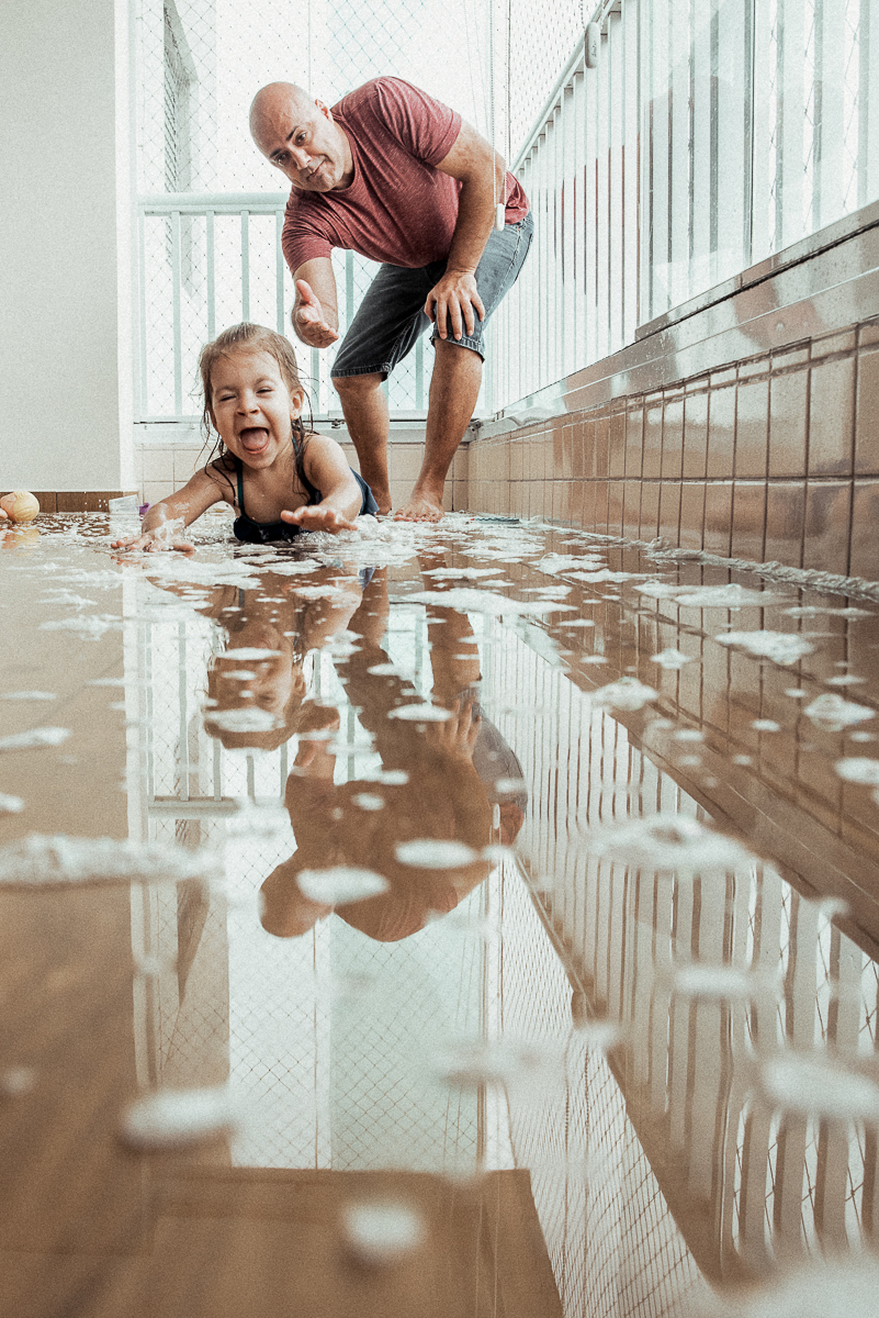 Fotografia de familia fotos feitas em casa ao natural da familia mae pai e duas filhas com pijama acordando brincando no predio. fotos feitas pela fotografa premiada nayara andrade de santos litoral de sao paulo