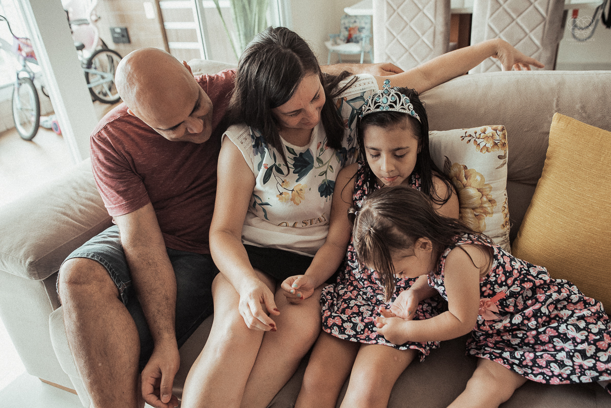 Fotografia de familia fotos feitas em casa ao natural da familia mae pai e duas filhas com pijama acordando brincando no predio. fotos feitas pela fotografa premiada nayara andrade de santos litoral de sao paulo