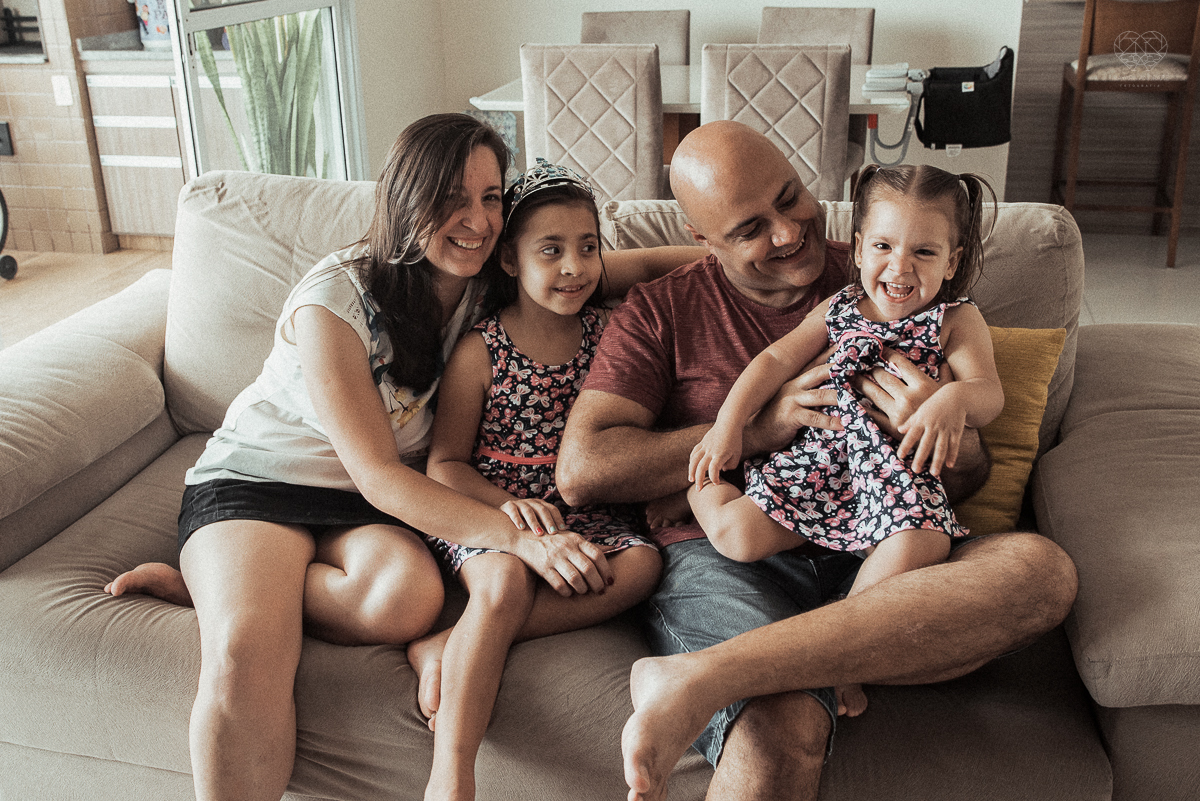 Fotografia de familia fotos feitas em casa ao natural da familia mae pai e duas filhas com pijama acordando brincando no predio. fotos feitas pela fotografa premiada nayara andrade de santos litoral de sao paulo