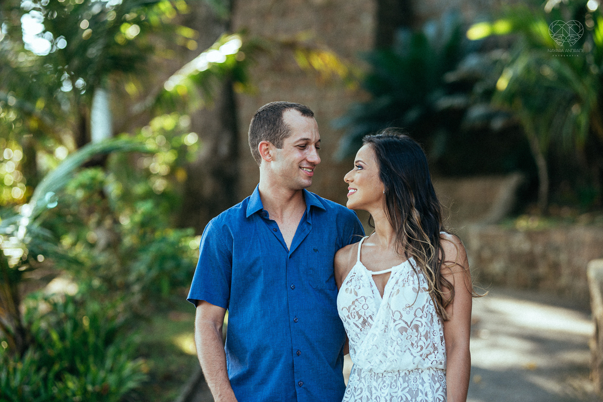 fotografia pre wedding de casal na praia noiva de vestido branco casal fazendo fotos em poses inspiração pela fotografa nayara andrade lindo por do sol colorido e fotos artisticas pela fotografa premiada mundialmente casamentos de dia inspiração