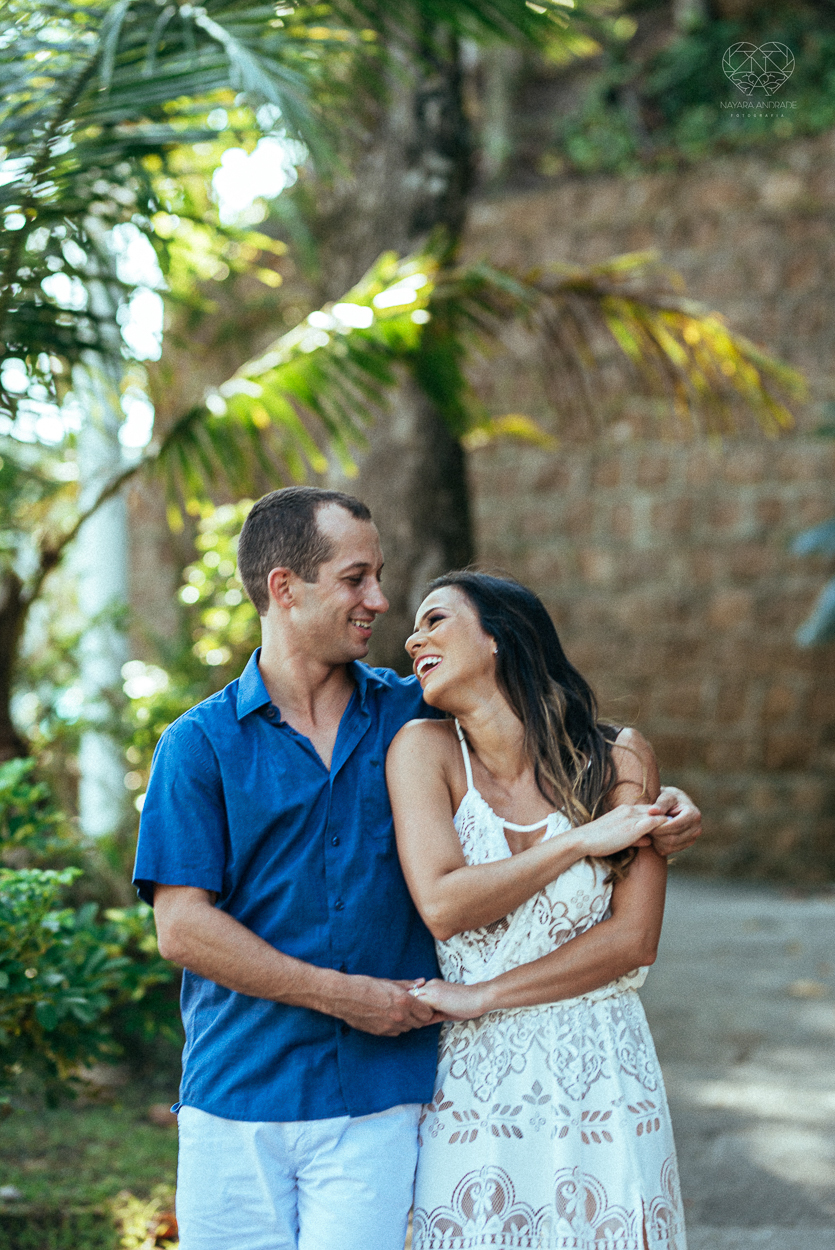 fotografia pre wedding de casal na praia noiva de vestido branco casal fazendo fotos em poses inspiração pela fotografa nayara andrade lindo por do sol colorido e fotos artisticas pela fotografa premiada mundialmente casamentos de dia inspiração