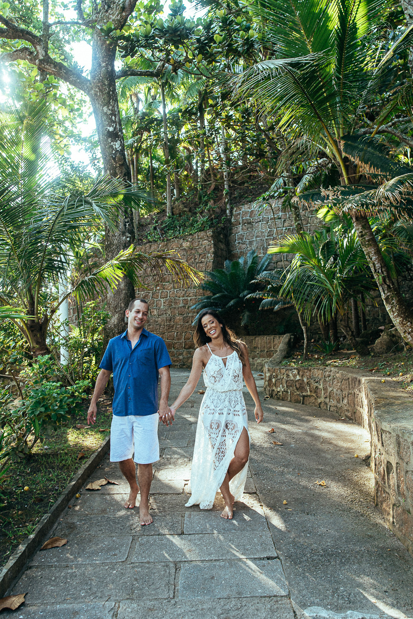 fotografia pre wedding de casal na praia noiva de vestido branco casal fazendo fotos em poses inspiração pela fotografa nayara andrade lindo por do sol colorido e fotos artisticas pela fotografa premiada mundialmente casamentos de dia inspiração