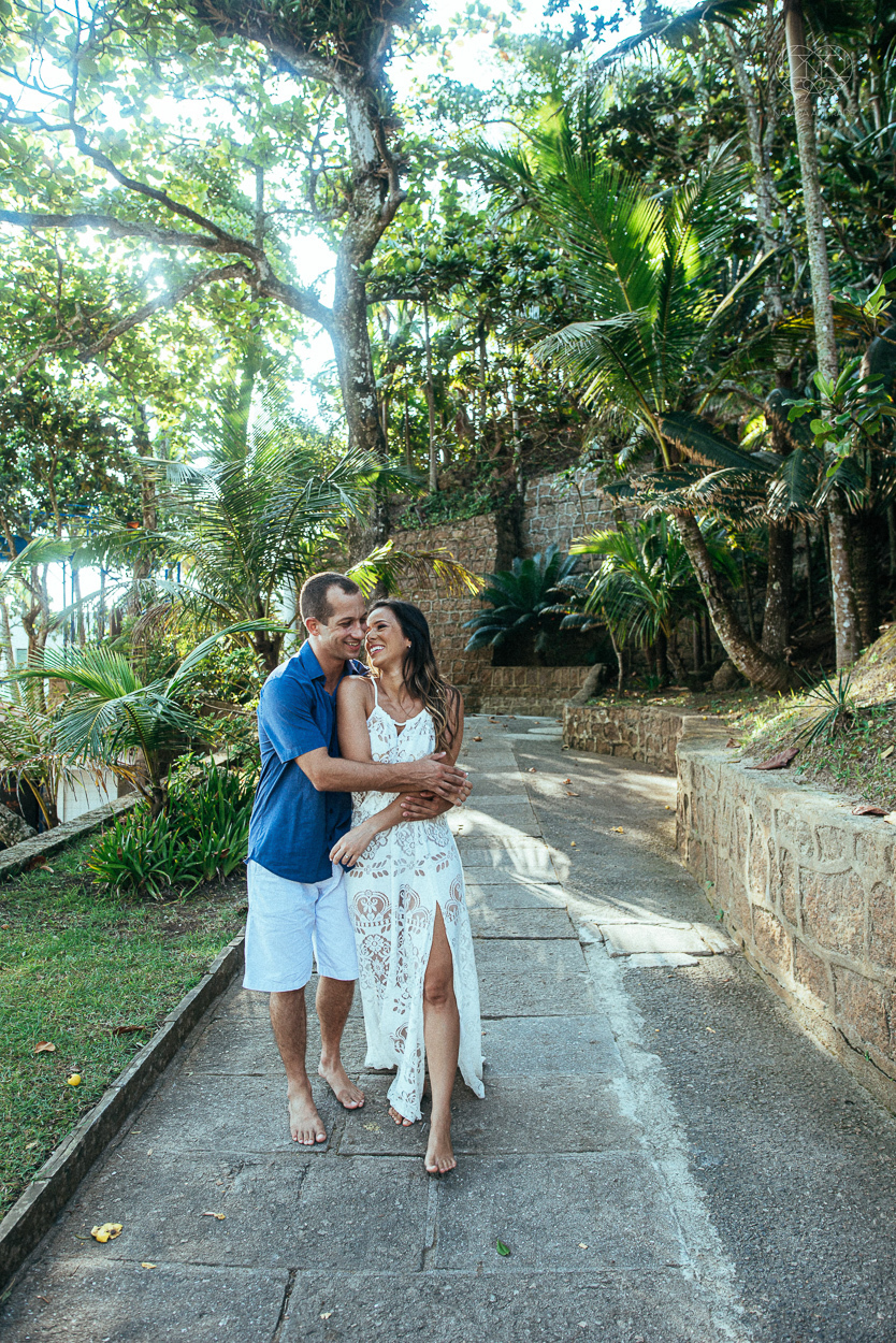 fotografia pre wedding de casal na praia noiva de vestido branco casal fazendo fotos em poses inspiração pela fotografa nayara andrade lindo por do sol colorido e fotos artisticas pela fotografa premiada mundialmente casamentos de dia inspiração