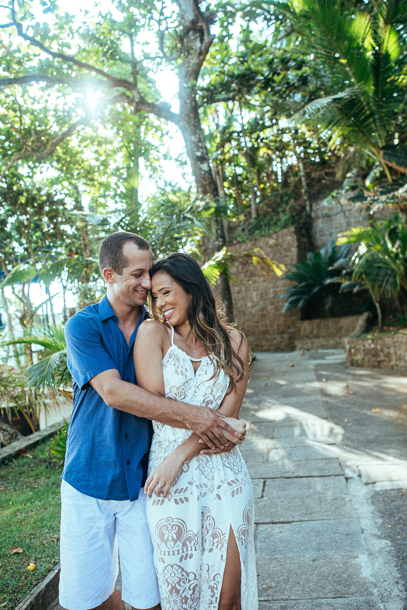 fotografia pre wedding de casal na praia noiva de vestido branco casal fazendo fotos em poses inspiração pela fotografa nayara andrade lindo por do sol colorido e fotos artisticas pela fotografa premiada mundialmente casamentos de dia inspiração