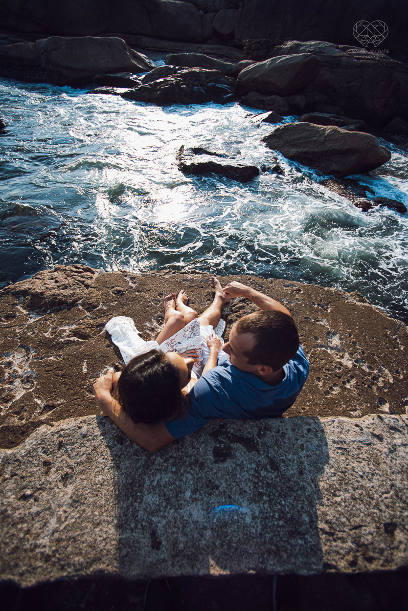 fotografia pre wedding de casal na praia noiva de vestido branco casal fazendo fotos em poses inspiração pela fotografa nayara andrade lindo por do sol colorido e fotos artisticas pela fotografa premiada mundialmente casamentos de dia inspiração