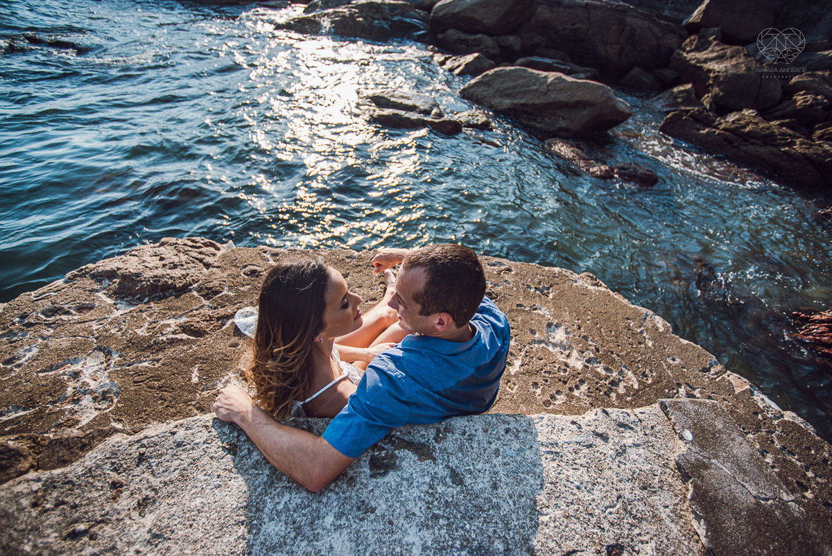 fotografia pre wedding de casal na praia noiva de vestido branco casal fazendo fotos em poses inspiração pela fotografa nayara andrade lindo por do sol colorido e fotos artisticas pela fotografa premiada mundialmente casamentos de dia inspiração