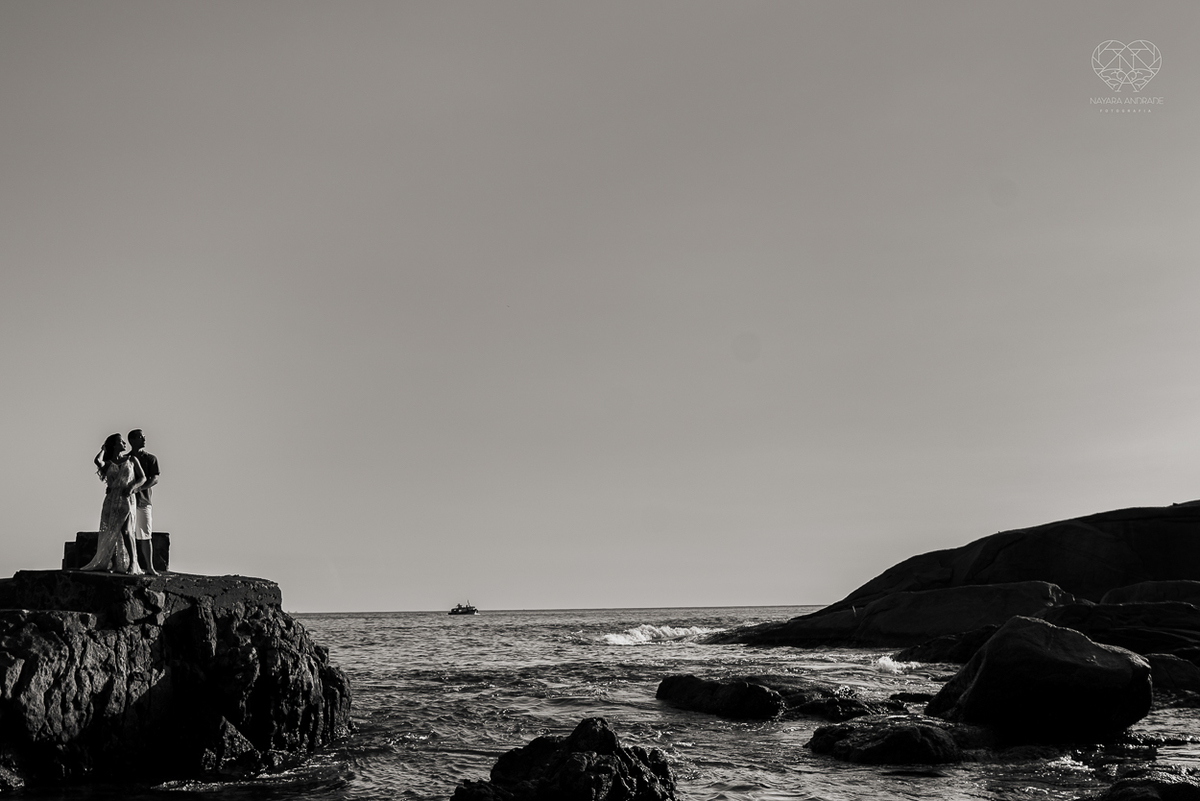 fotografia pre wedding de casal na praia noiva de vestido branco casal fazendo fotos em poses inspiração pela fotografa nayara andrade lindo por do sol colorido e fotos artisticas pela fotografa premiada mundialmente casamentos de dia inspiração