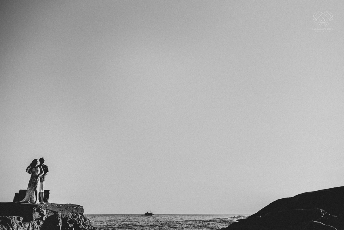 fotografia pre wedding de casal na praia noiva de vestido branco casal fazendo fotos em poses inspiração pela fotografa nayara andrade lindo por do sol colorido e fotos artisticas pela fotografa premiada mundialmente casamentos de dia inspiração