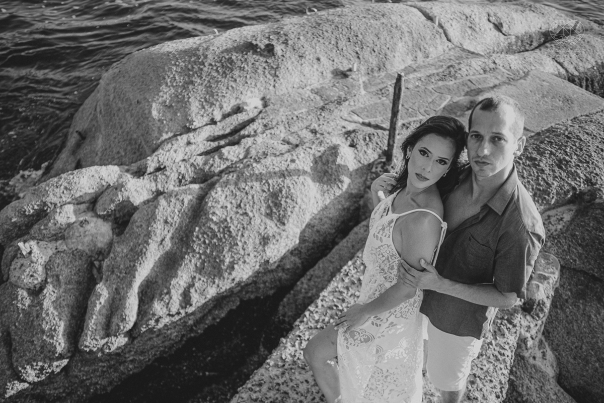 fotografia pre wedding de casal na praia noiva de vestido branco casal fazendo fotos em poses inspiração pela fotografa nayara andrade lindo por do sol colorido e fotos artisticas pela fotografa premiada mundialmente casamentos de dia inspiração